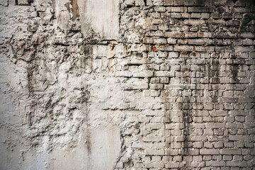 Abandoned vintage white brick wall exterior with rough surface