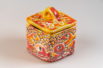 Color porcelain tin with cap on white background with reflection