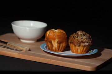 breakfast, snack, milk with handmade muffins on wooden tray with dark background.