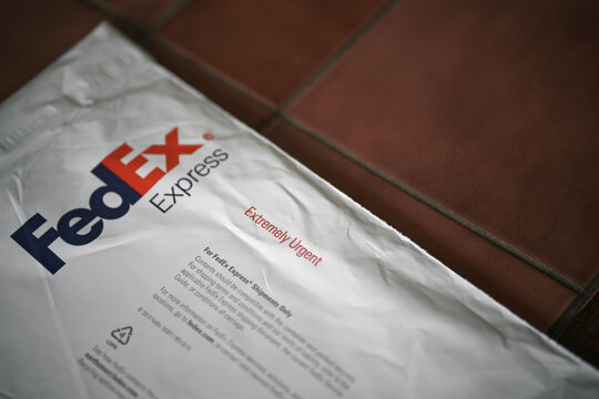 FedEx Express parcel. Lifestyle picture of the FedEx shipping bag on dark table background