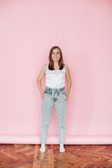 Handsome girl in summer clothes rejoices, picture isolated on pink background