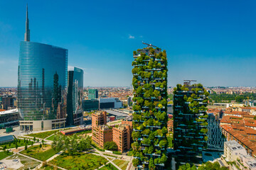 Aerial view of building called Bosco Verticale in front of office buildings. Vertical Forest, in Milan, Porta Nuova district. Residential buildings with many trees and other plants in balconies