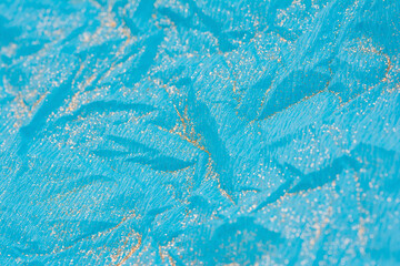 Abstract macro blue crumpled paper background with gold glitter