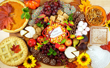 Happy Thanksgiving cheese and dessert grazing platter charcuterie board with pumpkin and apple pie.