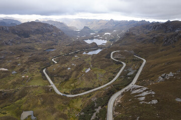 A long road splicing through the Andes Mountains and lagoons