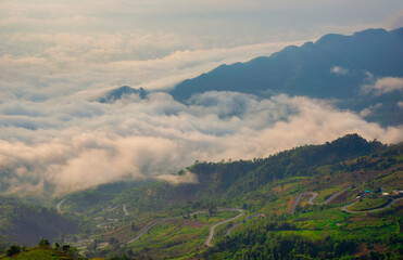 cars driving on curved, zigzag curve road or street on mountain hill with green natural forest trees in rural area of Phu Tub Berk, Phetchabun, Thailand.