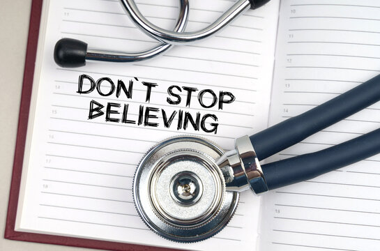 On the table is a stethoscope, a pen and a notebook in which it is written - Dont Stop Believing