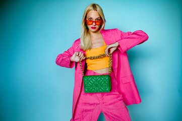 Fashion portrait of confident woman wearing trendy summer pink fuchsia color suit, orange...