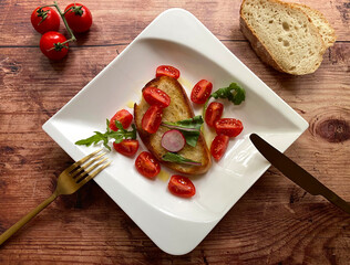 Mediterraner, vegetarische Tomaten Brotsalat mit Ciabatta Brot, Kirschtomaten, Rucola und Olivenöl. 