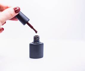 Naklejka premium black bottle of gel nail polish with brush isolated on white background, advertising nail polishes