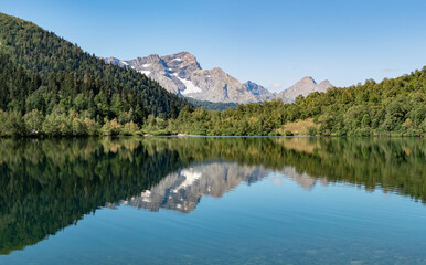 Fototapeta na wymiar Panoramic view of Kardyvach lake with Agepsta mountain reflection on water surface. Travel destination in Caucasus, Russia