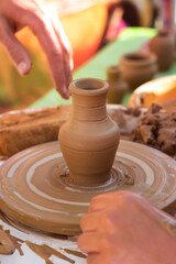 Master class in making a jug from clay, an adult teacher teaches a child to make clay products