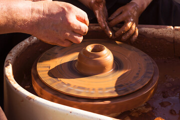 Master class in making a jug from clay, an adult teacher teaches a child to make clay products