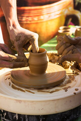 Master class in making a jug from clay, an adult teacher teaches a child to make clay products