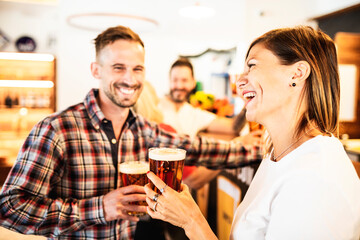 Guys have fun at the bar drinking beer.