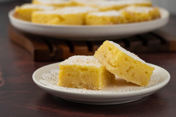 Homemade lemon bars dessert on a white plate on the table