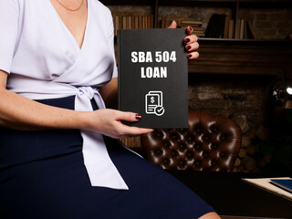 Business concept meaning SBA 504 LOAN with phrase on black notepad.