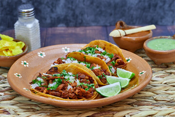 Tacos al pastor, tradicional comida mexicana, con cebolla, cilantro, pi&ntilde;a, salsa roja o guacamole.
