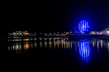 The lights of the Santa Monica Pier, the Ferris wheel and the Rollercoaster reflected in the water...