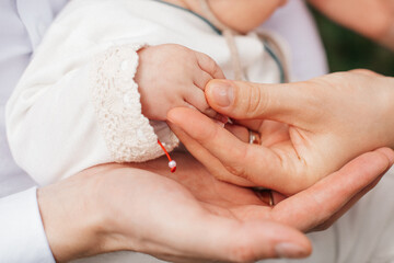 kleine Hand eines Neugeborenen in den Armen der Mutter
