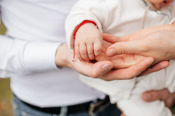 small hands of a newborn in the hands of loving parents