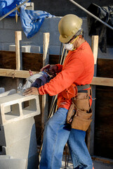 Mason cutting concrete blocks on a construction site