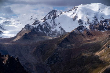Rocks of the highlands, the road among the snow-capped peaks.