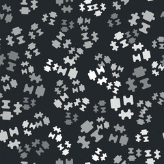 Grey Puzzle pieces toy icon isolated seamless pattern on black background. Vector