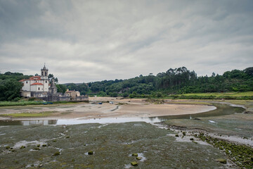 Church of Nuestra Se&ntilde;ora de los Dolores in the estuary of the village of Barro at low tide, Llanes Asturias Spain