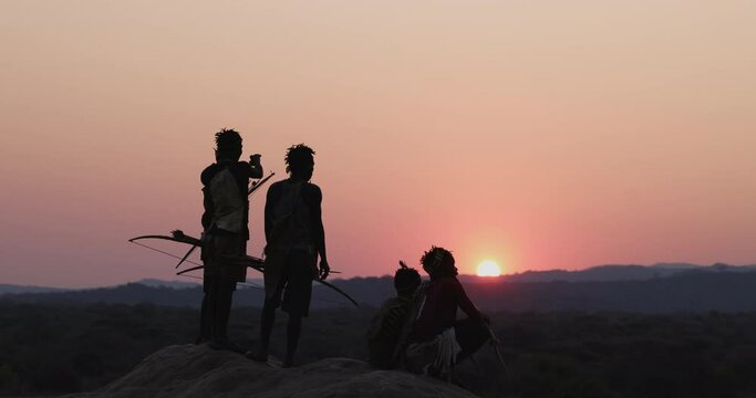 Group of Hadza hunter-gatherer tribesmen out hunting at sunset Tanzania