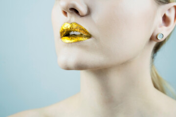 Golden Metal gold lips. Beautiful makeup. bright paint on beautiful model woman mouth, close-up.