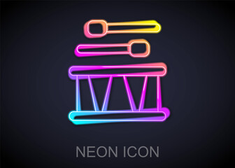 Glowing neon line Drum with drum sticks icon isolated on black background. Music sign. Musical instrument symbol. Vector