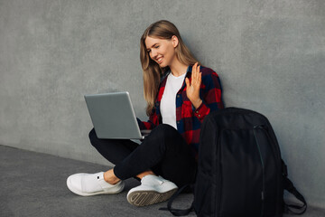 Happy woman using video conference on laptop, calling friend from distance in virtual chat, in city...