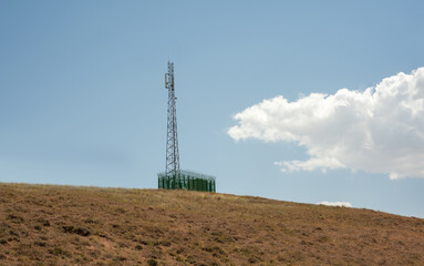rounded hill with Radio tower and blue cloudy sky in kurdistan province, Iran