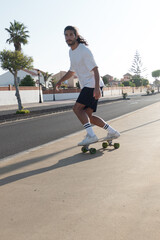 Fototapeta premium Young caucasian italian man skating on his surfskate outdoors in a sunny summer day