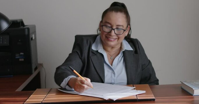 Mujer de negocios de la tercera edad revisando documentos en su oficina.