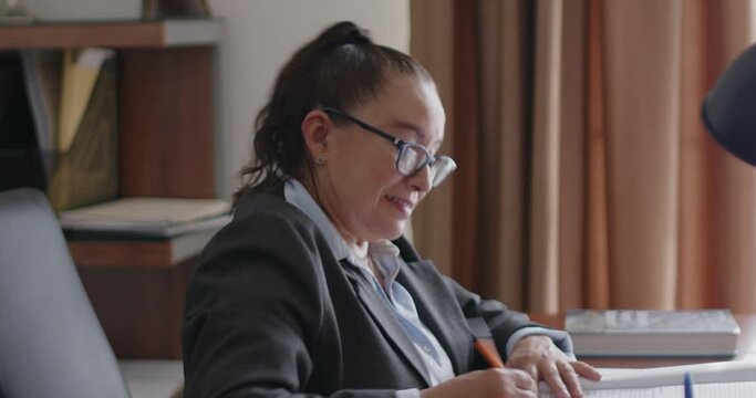 Mujer de negocios de la tercera edad revisando documentos en su oficina.