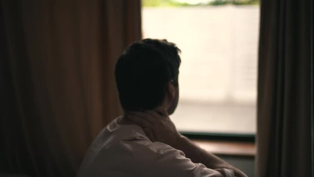 man feels neck pain after waking up