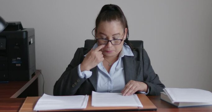 Mujer de negocios de la tercera edad revisando documentos en su oficina.