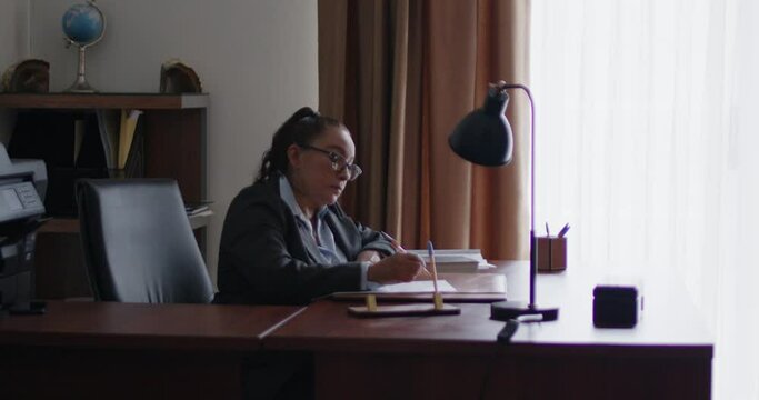 Mujer de negocios de la tercera edad revisando documentos en su oficina.