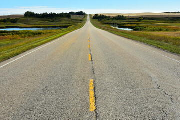 An image of a deserted old rural asphalt highway on a clear sunny day.  