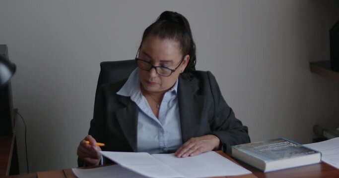 Mujer de negocios de la tercera edad revisando documentos en su oficina.