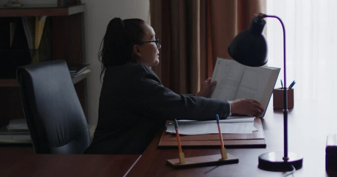 Mujer de negocios de la tercera edad revisando documentos en su oficina.