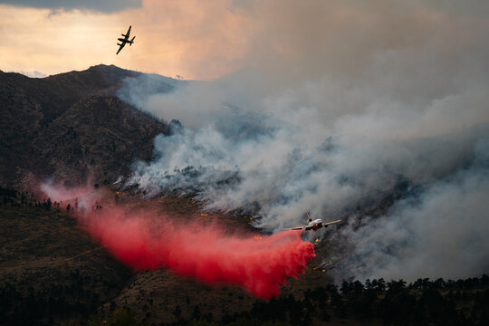 A spotter plane guides in a Slurry Bomber to help contain the Cal-Wood Fire in Boulder, Colorado 2020