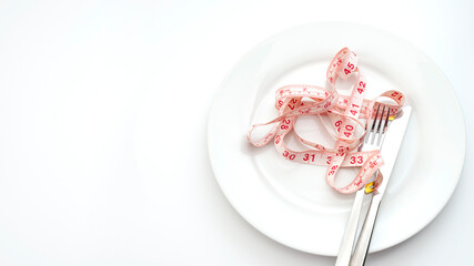 Anorexia and bulimia, eating disorder and weight loss concept with empty plate and measuring tape isolated on white background with copy space