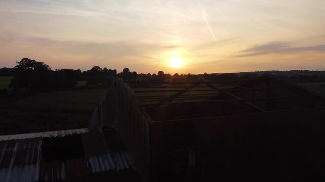 Silhouette Of Derelict Barn Against Sunset Skies. Aerial Dolly Forward