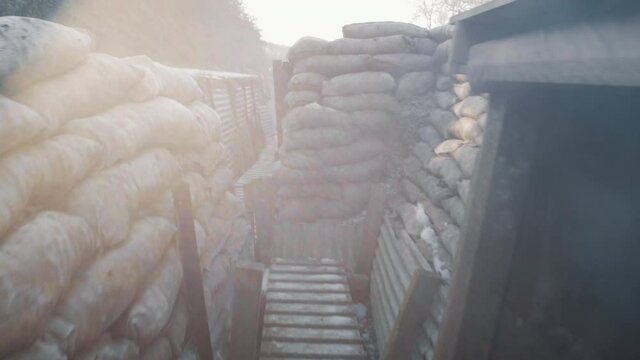 Walking through a world war one trench. The ww1 dug out has sand bags on each side.