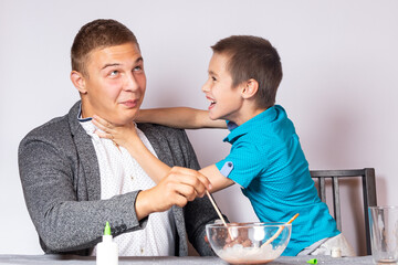 Chemistry education and training concept. Close-up of a boy and his father doing a home chemistry experiment and having fun fooling around