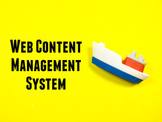 Business concept.Text WEB CONTENT MANANGEMENT SYSTEM with toy ship on a yellow background.