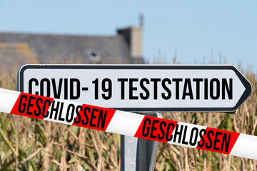 Schild auf Covid-19 Teststation und Absperrband Geschlossen